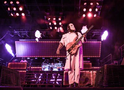 Slipknot bassist Alessandro Venturella stands triumphantly as he strums his proverbial axe.