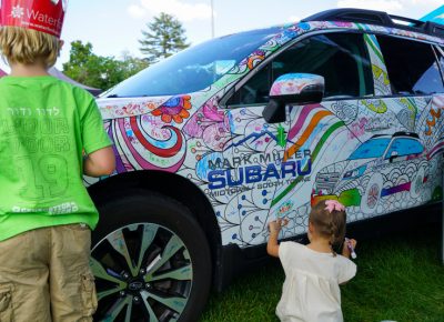 Children doing some art work on the Subaru.