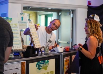 Bartender in the Harmons VIP Area explaining the different drinks to an attendee.