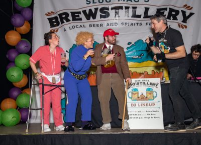 (L–R) Geriatric Wonders Angelica Furman, Amelia Landay and Patrick Blythe receive much-earned praise from SLUG Magazine’s John Ford. They took first place in the Boo!stillery costume contest.