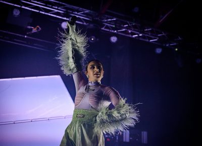 Charli holds the mic up high as her fans sing along at The Complex.