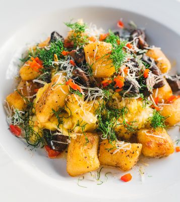 The tender pasta dumplings of Tradition's Gnochi are sautéed with mushrooms and served over tender cauliflower on top of an acorn-squash purée.