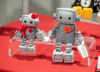 GINNYPENNY’s felt robots are sold as kits or assembled robots. Craft Lake City’s merch booth sells a GINNYPENNY robot kit as a fundraiser.