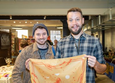 (L–R) Matt Kastellec and Nick Hoffman volunteered to help with load-out after the market closed. In the meantime, Hoffman bought a bandana that will tickle the Christmas bone of a colleague who’s obsessed with lunar eclipses.