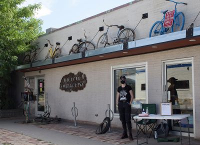 A SLUG Cat volunteer represents SLUG in front of the SLC Bicycle Collective.