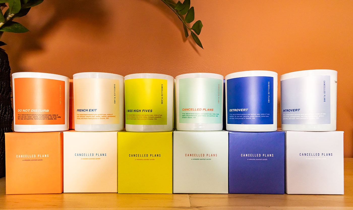 Scented candles on display against orange background at The Stockist