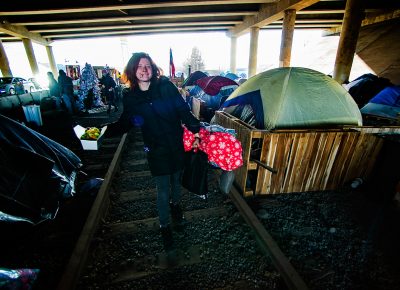 A woman named Ash heads to her tent after making a salad in the kitchen area at Camp Last Hope, on Tuesday, Jan. 5, 2021. As a vegetarian, she was delighted to see that fresh lettuce had been donated today.