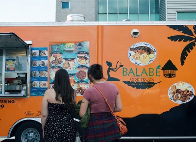 Hungry attendees look over Balabé Senegalese Cuisine's menu.