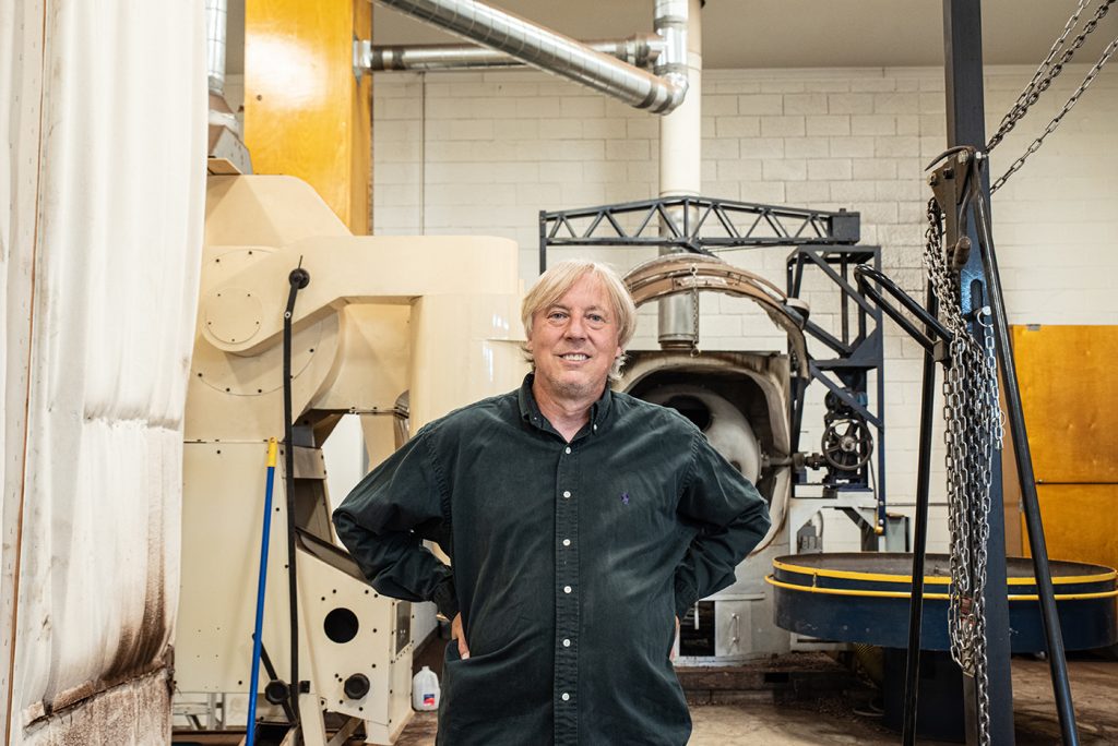 Art Pollard poses in front of Amano Chocolate equipment.