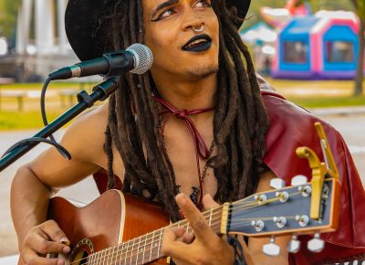 Muscian Zaza providing music for the Busking Bus Theatre Company.