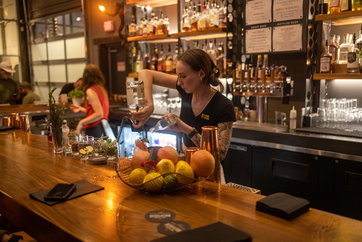 Beehive Distilling Bar Manager Kelsey Terrell serves up drinks to patrons on a busy weekend night.