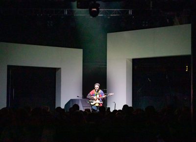 Marinelli playing on stage with the set pieces of giant white arches behind him all ready for the next set.