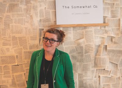 A vendor poses in front of her custom built backdrop.