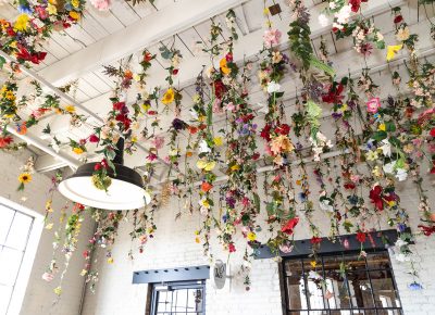 A flower ceiling dangles over patrons at Holiday Market.