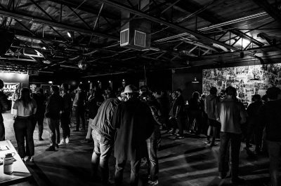 People gather around the stage and line up behind the bar while listening to Death By Salt artists.