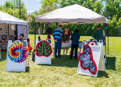 Moe, owner of Tough Tufts, talks to two festival goers about her rug-making process.