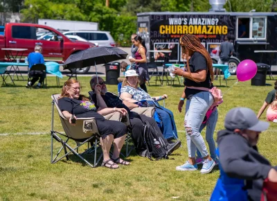 Festival goers enjoy talking to each other while live music plays in the background.