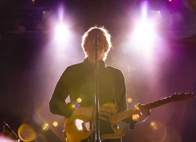 Britt Daniel of Spoon sings while playing guitar.