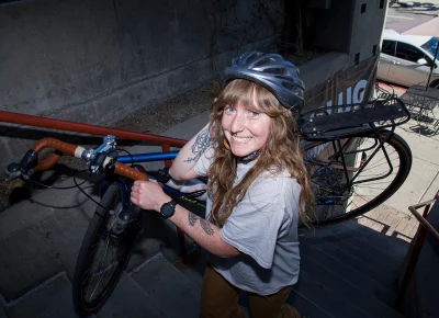 India Alfonso carries her bike up a flight of stairs.