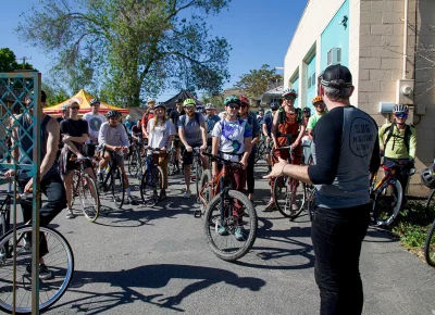 John Ford explains the SLUG Cat details to participants on bicycles.