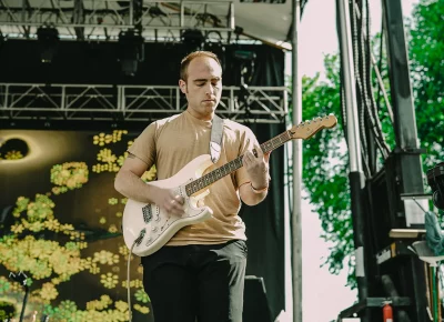 Live musician strums instrument during performance