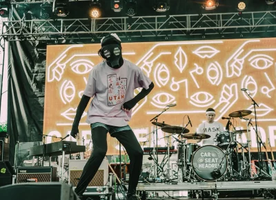 Live performer wearing cloth-covered gas mask on stage