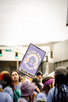 Parker Mortensen waves a SLUG Mag Pride sign.