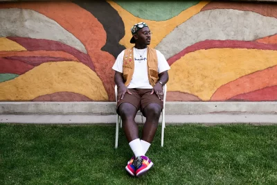 James Ray Davis III sitting in a chair against a colorful backdrop.