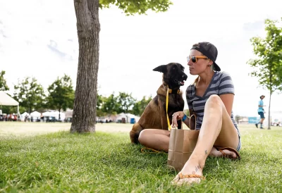 DIY Festival goers Aria Mandi and Bitnei the dog, enjoying a rest under a tree.