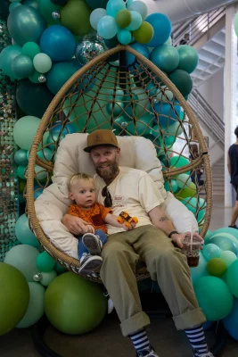 Parent and child relax in the Dreamer's building after browsing vendors.