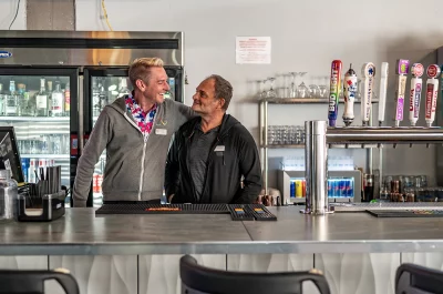 Riley Richter and Micheal Repp stand looking at each other at the bar at Club Verse. Photo: Ashley Christenson