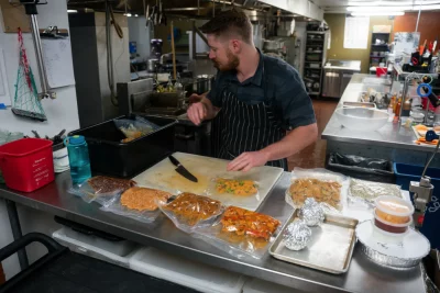 Man prepares food in a restaurant kitchen.