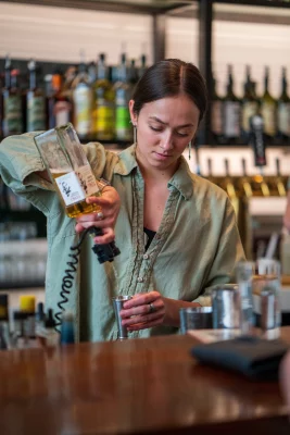 An employee pours whiskey while bartending at Post Office Place.