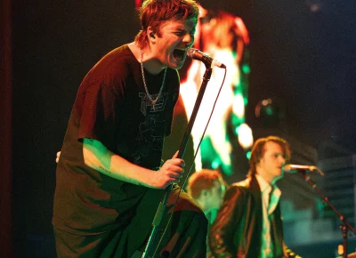 Lead singer Grian Chatten leaning into the mic.