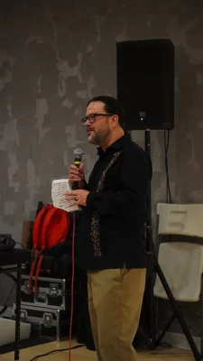 Horacio Rodriquez holding a piece of paper and a microphone.