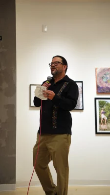 Horacio Rodriquez holding a piece of paper and a microphone.
