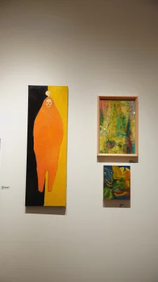 A gallery wall with three framed paintings.