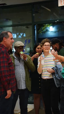 A group of gallery attendees discussing the works on display.