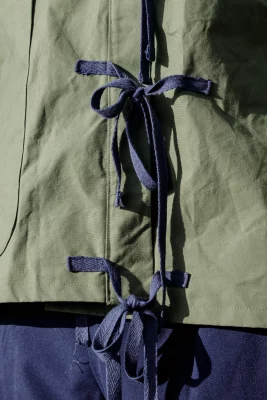 A green and blue jacket designed by Brennah with blue ties on the front.