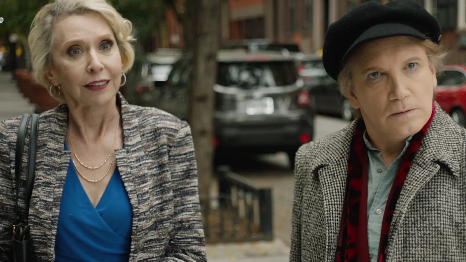 Two people stand on a sidewalk looking toward the camera in a still from The Sixth Reel.