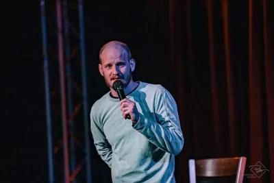 Michael Davis holds a microphone while performing onstage.