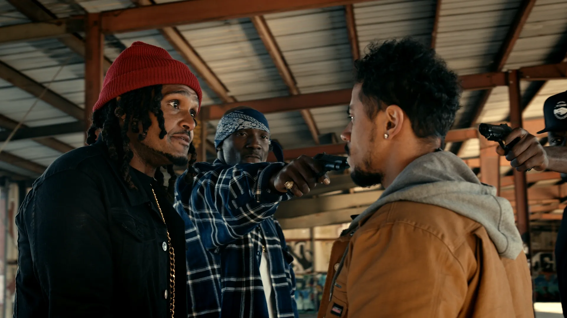 Three men stand together in warm, bundled clothing. One of them points a gun at another. Still from Run Nixon.