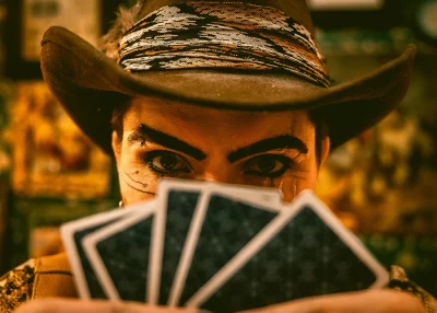 Heller Highwater peeks over a hand of cards