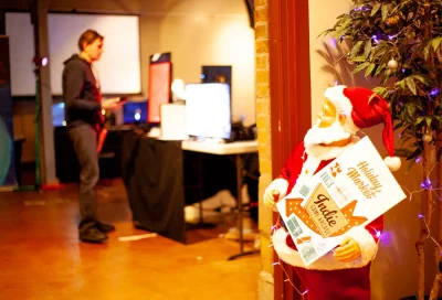 A Santa animatronic holds a Holiday Market sign.