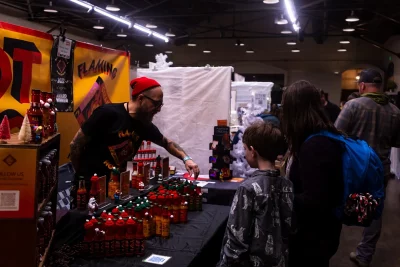 Visitors wait at Flaming Homer's Hot Sauce booth.