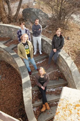No Such Animal sits and stands on a stone staircase, photographed from an overhead view.