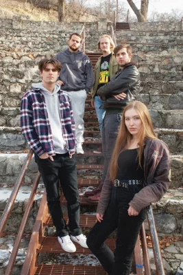 The members of No Such Animal stand staggered on a metal staircase.