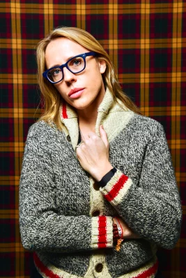 Slamdance Festival Director Taylor Miller stands in front of a plaid backdrop.