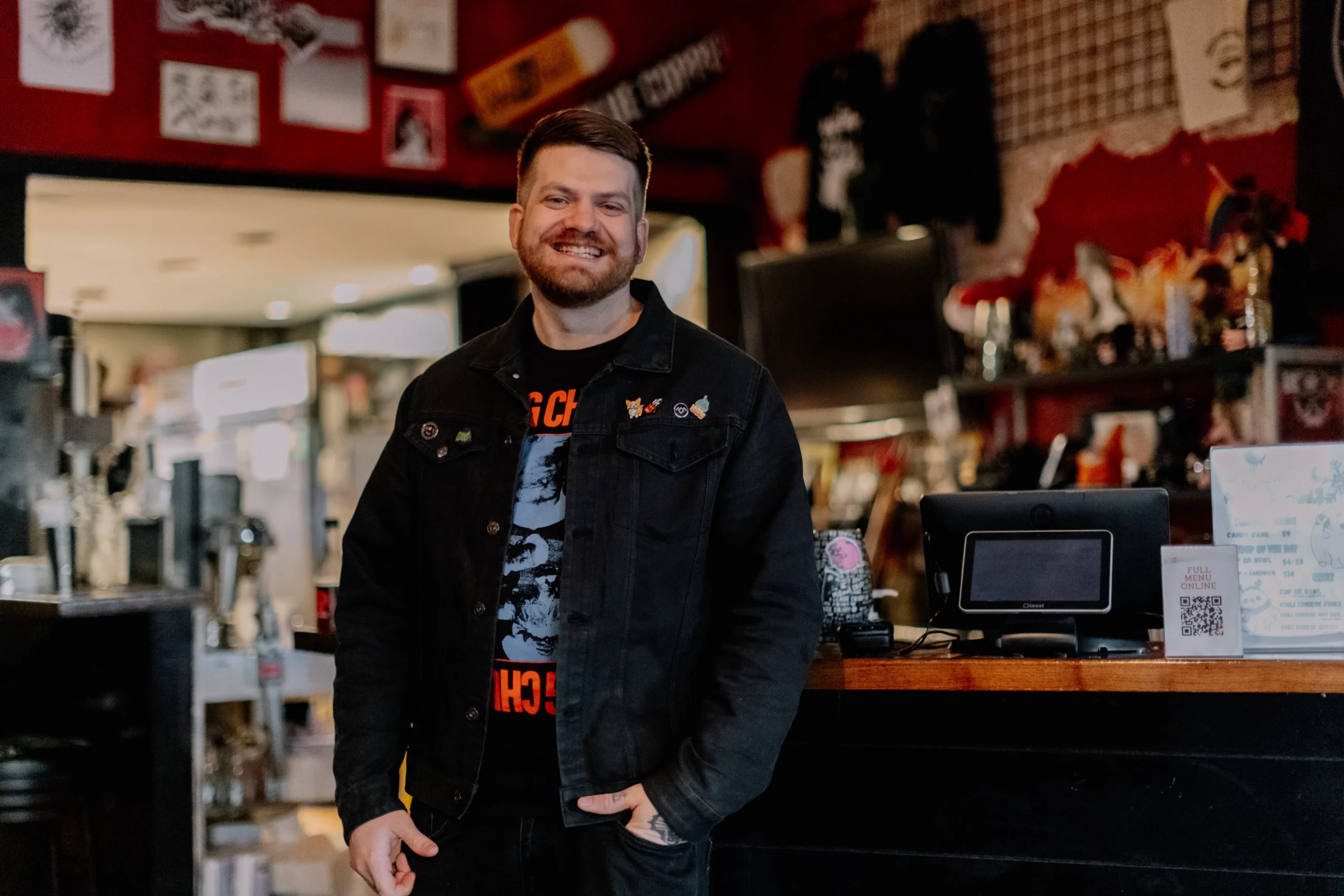 Andrew Earley smiles standing in front of the Mark of the Beastro restaurant.