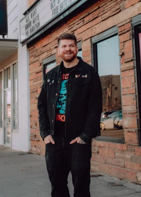 Earley stands in front of the brick building that houses The Beehive.